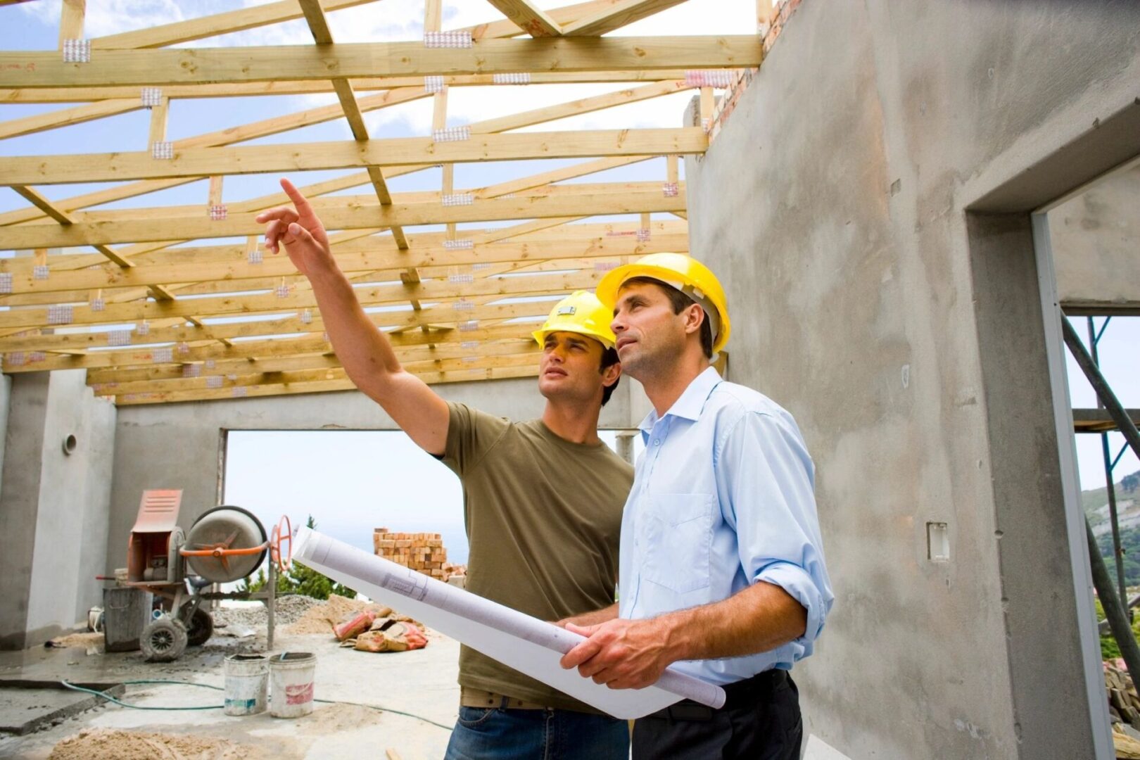 Two men in hard hats looking at a building