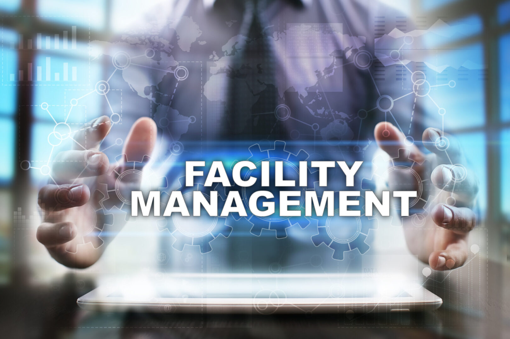 A man holding a laptop with the words facility management.