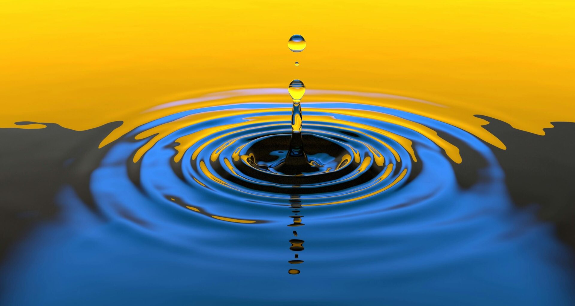 A water drop falling into the ocean with a yellow sky in background.